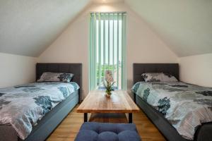 two beds in a room with a table between them at Ferienwohnung Alpenblick in Friedrichshafen
