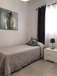 sypialnia z łóżkiem i obrazem na ścianie w obiekcie La Gaviota w mieście Arrecife