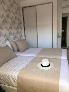 un chapeau assis au-dessus d'un lit dans l'établissement Sonho do Mar Ap., à Nazaré