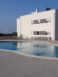 une piscine en face d'un bâtiment dans l'établissement Sonho do Mar Ap., à Nazaré