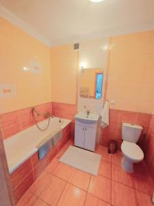 a bathroom with a tub and a toilet and a sink at Modlinska Apartments in Nowy Dwór Mazowiecki