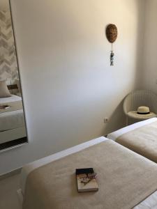 - une chambre avec 2 lits et un livre sur le lit dans l'établissement Sonho do Mar Ap., à Nazaré