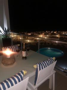 - une table avec une bouteille de vin et 2 chaises dans l'établissement Sonho do Mar Ap., à Nazaré