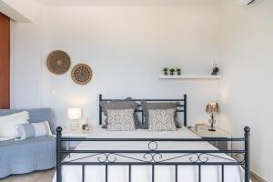 a bedroom with a bed with a white wall at Villaki in Maroulás +16 photos