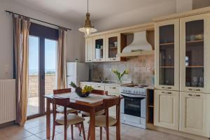 Maroulás的住宿－Villaki，一间带木桌的厨房和一间餐厅
