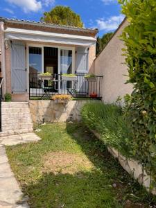 uma casa com um alpendre com uma mesa em Un petit coin sympa em Draguignan