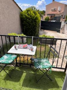 uma mesa branca e 2 cadeiras numa varanda em Un petit coin sympa em Draguignan