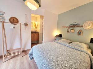een slaapkamer met een bed met een blauwe deken bij La Tiny proche lac et forêt in Sillé-le-Guillaume