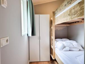 een slaapkamer met een stapelbed en een raam bij Nieuw! OK40 Landelijk gelegen Chalet in Oostkapelle