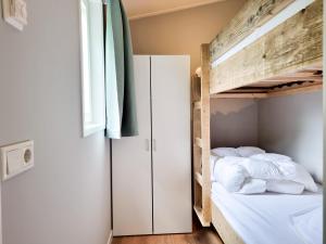 a bedroom with a bunk bed and a window at Landelijk gelegen Chalet OK40 in Oostkapelle