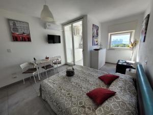 a bedroom with a large bed with red pillows at Rosato Sea View Apartment in Lignano Sabbiadoro