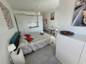 a bedroom with a bed with red pillows on it at Rosato Sea View Apartment in Lignano Sabbiadoro