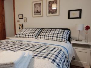 a bed with a blue and white checkered blanket at B&B A casa di Carla in Castelsaraceno +57 photos