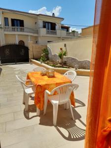 una mesa y sillas en un patio frente a una casa en Casa Adelina, en Giurdignano