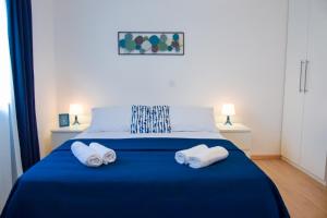 Un dormitorio con una cama azul con toallas. en Locus Apartments, en Petrčane
