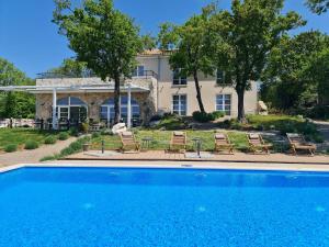 a swimming pool in front of a house at Boutique Resort OSMA in Malinska