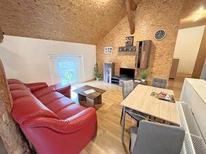 ein Wohnzimmer mit einem roten Sofa und einem Tisch in der Unterkunft Ferienwohnung Oberuckersee OT Melzow UCK 1152 in Melzow