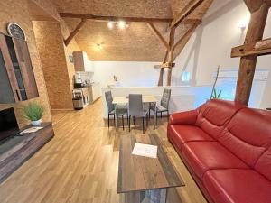 ein Wohnzimmer mit einem roten Sofa und einem Tisch in der Unterkunft Ferienwohnung Oberuckersee OT Melzow UCK 1152 in Melzow