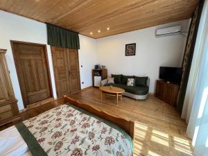 ヴェリコ・タルノヴォにあるTsarevets Residenceのベッド、ソファ、テーブルが備わる客室です。