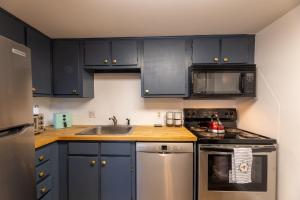 a kitchen with black cabinets and a stainless steel appliance at Snowshoe Ski-in & Ski-out at Silvercreek Resort - Family friendly, jacuzzi, hot tub, mountain views in Snowshoe
