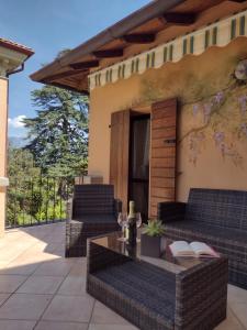 a patio with two wicker chairs and a table at Casa Gabri in Toscolano Maderno