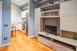 a living room with a tv and a kitchen at Bixio 45 in Parma +9 photos