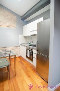 a kitchen with a stainless steel refrigerator and a table at Bixio 45 in Parma
