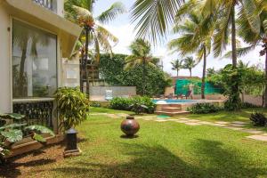 podwórko z dużą wazą w trawie w obiekcie Resort Coqueiral w mieście Candolim