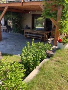 a wooden picnic table in a garden with a bench at Oustal in Savines +1 photo