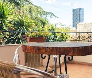 a wooden table on a balcony with plants at Garden Boutique B&B in Tirana