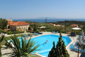 a person swimming in a swimming pool in a resort at Kefalonian Mill - Oneira Villas in Trapezaki