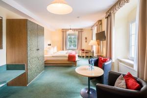 ノイウハウゼンにあるLandhaus Purschensteinのベッドとテーブルが備わるホテルルームです。