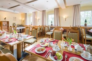 a restaurant with tables and chairs with food on them at Landhaus Purschenstein in Neuhausen