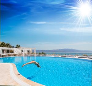 a man is swimming in a swimming pool at CHARM BEACH HOTEL in Akyarlar