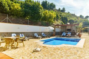 a swimming pool with chairs and a table and a table and a table and chairs at Villa Maravillas in Nerja