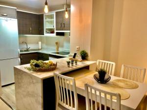 cocina con mesa con sillas y encimera en Blue Sunrise Penthouse - Manilva, en Manilva