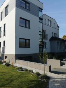 biały budynek z czarnymi oknami w obiekcie Chcę tu zostać Apartamenty Gdynia w mieście Gdynia +37 zdjęć