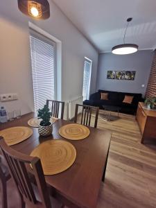 a dining room with a table and chairs and a couch at Chcę tu zostać Apartamenty Gdynia in Gdynia