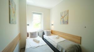 two beds in a room with a window at Apartamenty EverySky - Nad Łomnicą 1E-2B in Karpacz