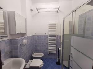łazienka z 2 toaletami, umywalką i prysznicem w obiekcie Dolfin - Nel centro di Stresa - By Impero House w mieście Stresa +8 zdjęć