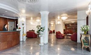 una hall con sedie rosse e un bar in un edificio di Hotel Gallia Palace a Rimini