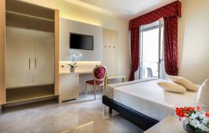 リミニにあるホテル ガリア パレスのベッドとデスクが備わるホテルルームです。