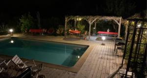 een zwembad in een tuin 's nachts bij chambre double avec salle de bain privée in Monacia-dʼAullène