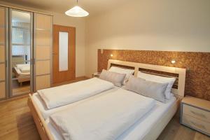 - une chambre avec un grand lit et des draps blancs dans l'établissement Ferienwohnungen Fanderl, à Riedenburg