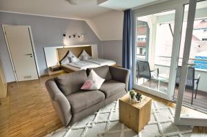 un soggiorno con un divano e un letto di Hotel Hagnauer Seeperle a Hagnau