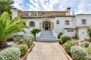 ein weißes Haus mit blauer Treppe davor in der Unterkunft Villas Guzman - Las Rosas in Benissa