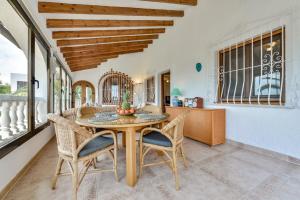 ein Esszimmer mit einem Holztisch und Stühlen in der Unterkunft Villas Guzman - Las Rosas in Benissa