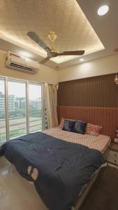 a bedroom with a bed with a ceiling fan at CITY HOMES ORCHID APARTMENT in Mumbai