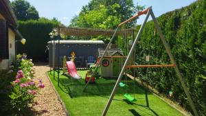 un jardín con parque infantil y columpio en Le Cottage de Maé en Seigy