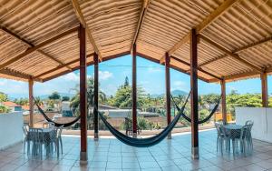 a hammock in a pavilion with tables and chairs at Pousada Bellasophia in Guarujá